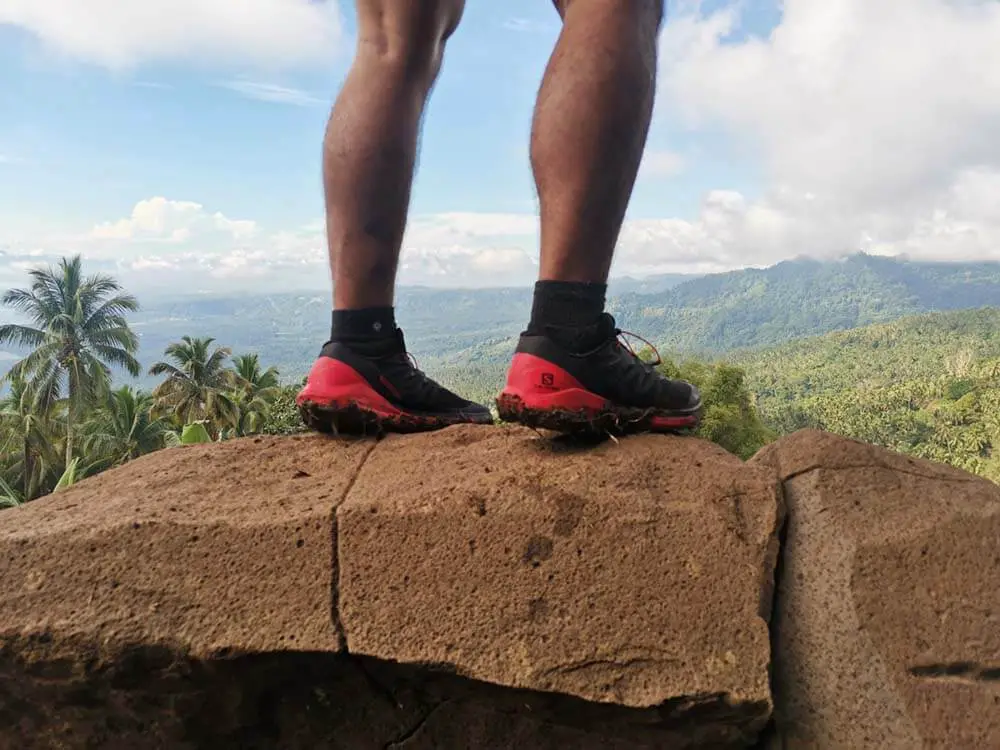 A photo of me standing on a rock wearing my Salomon Sense Ride 4 trail running shoes